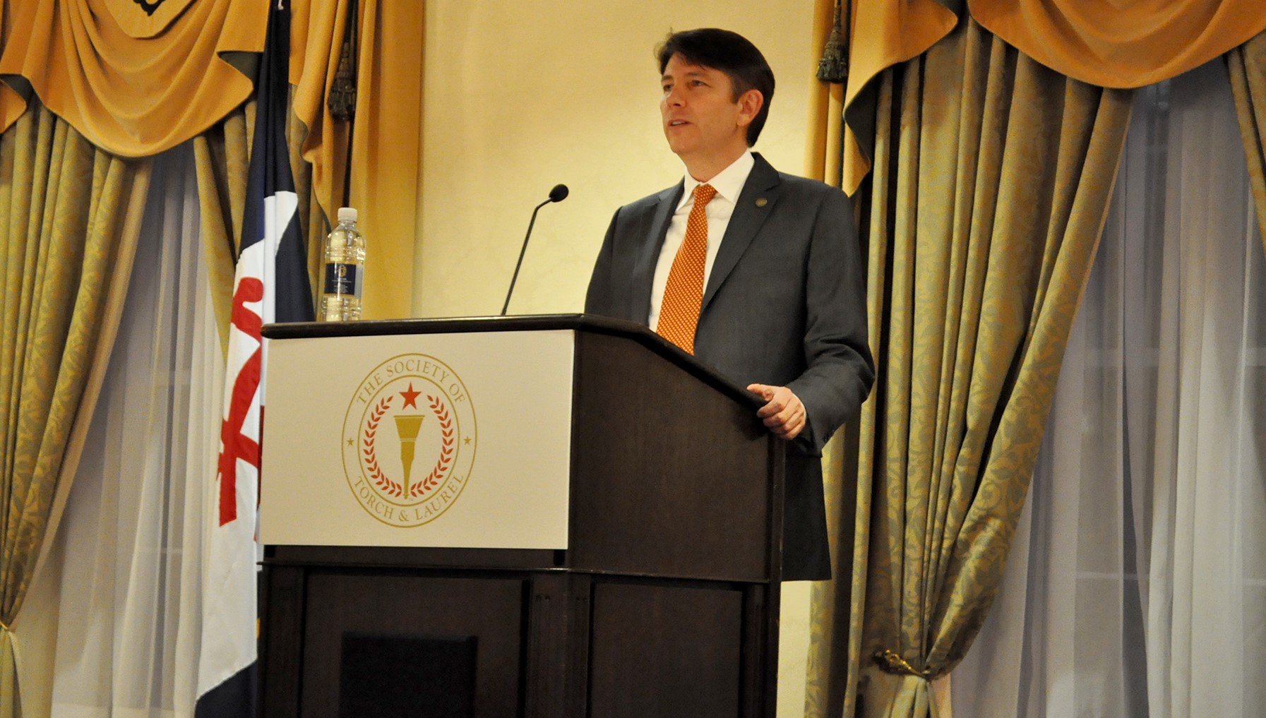 Steve Loflin, founder of Torch & Laurel behind podium